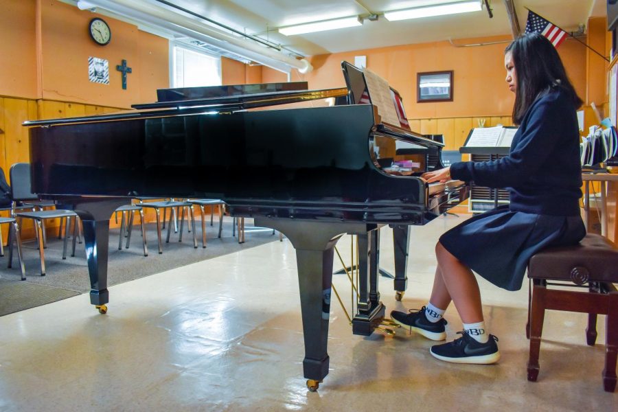 A student practices on the schools newly donated grand piano.