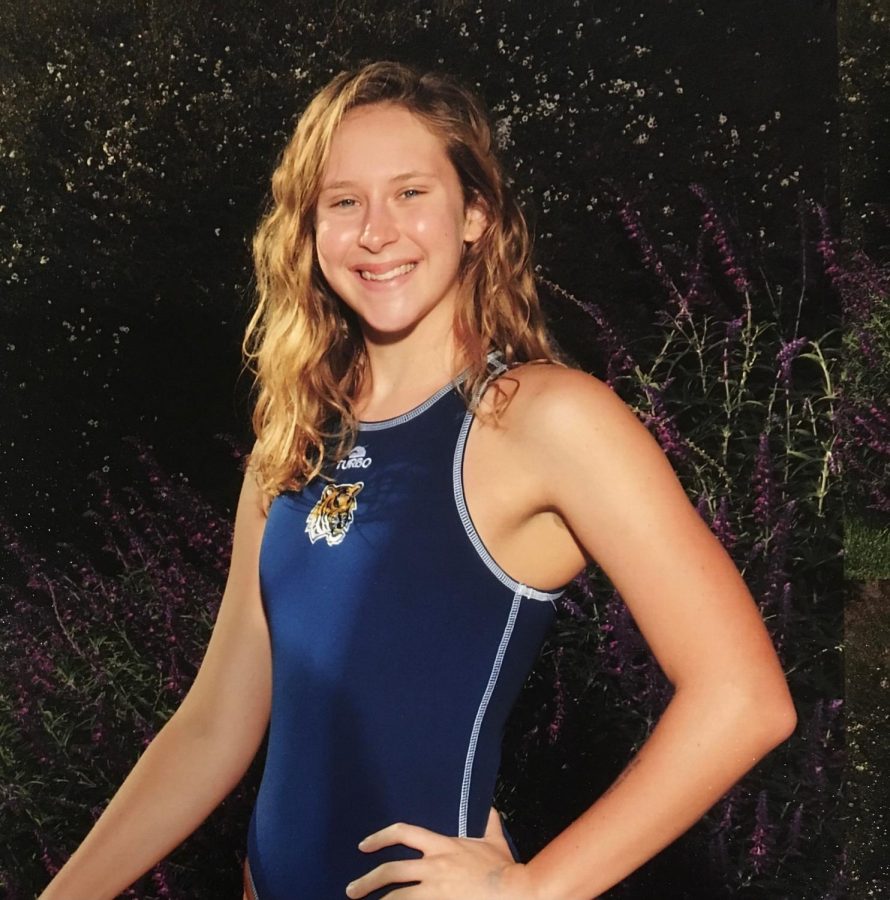 Rachel Schonfeld posing outside in her swim uniform.