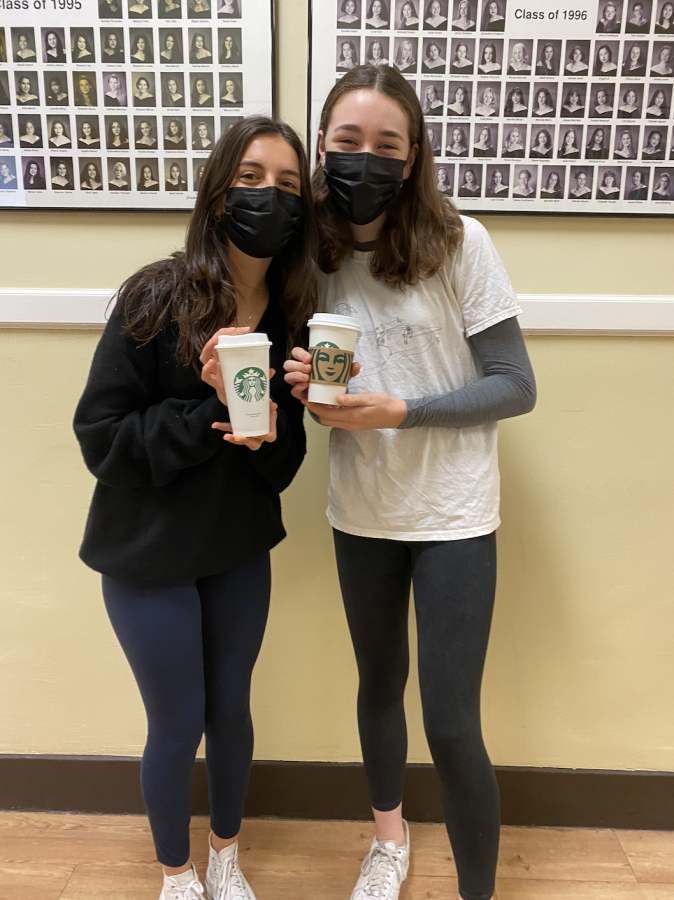 Mia Muzzi and Kayla Messick pose with their pumpkin spice lattes.