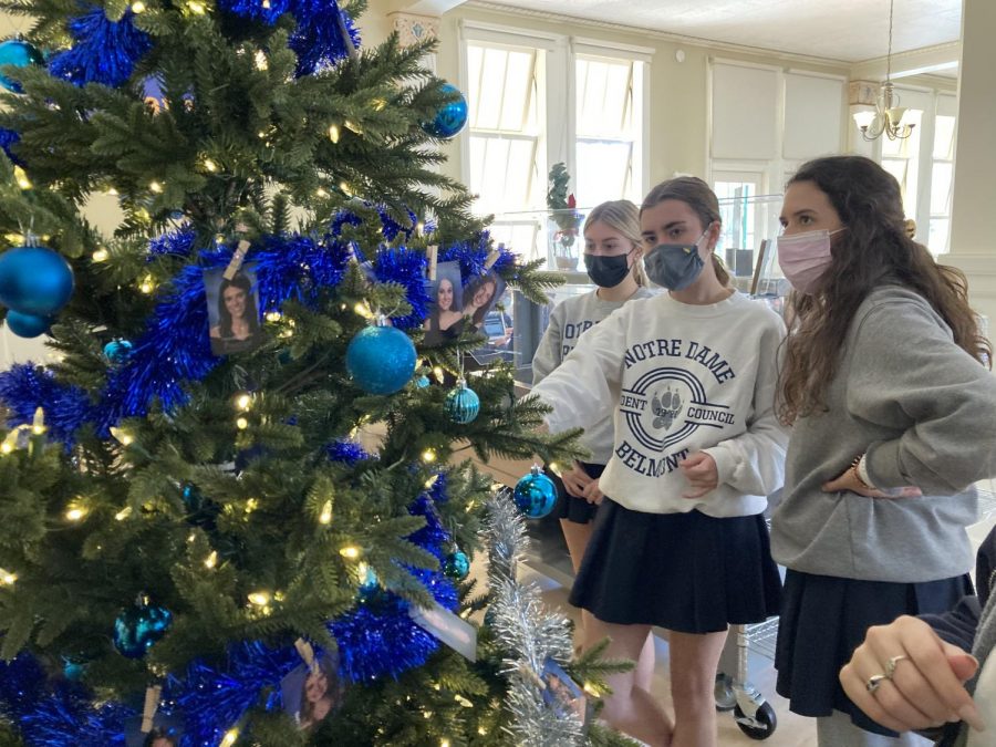 Seniors Catie Mahlman (left), Emma Treanor and Kyra Green help decorate the senior class Christmas tree in the dining hall.