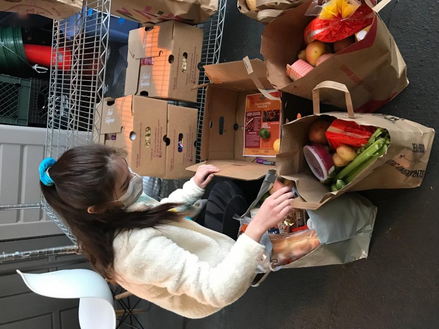 Ariel Lucas, NDB Key Club Secretary, helps fill bags of food for the food drive in partnership with non-profit group One Life Counseling Center.