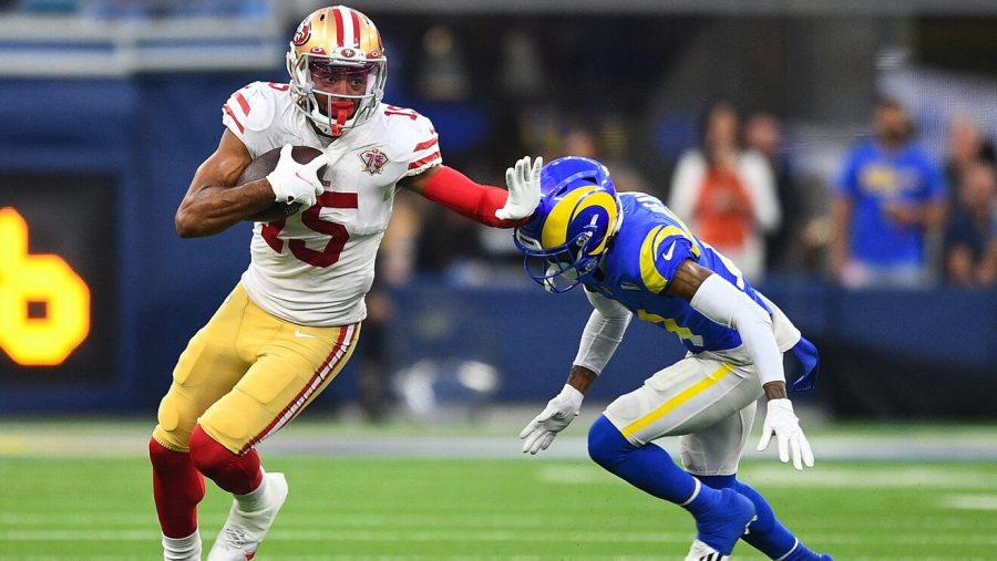 49ers wide receiver, Jauan Jennings (left), avoiding an incoming tackle by a Rams player (right) after catching a pass.