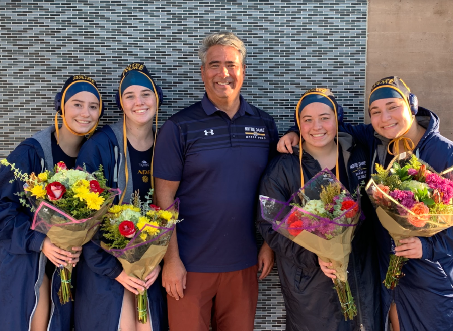 Senior varsity water polo players pose for a picture with Coach Mike Marques.