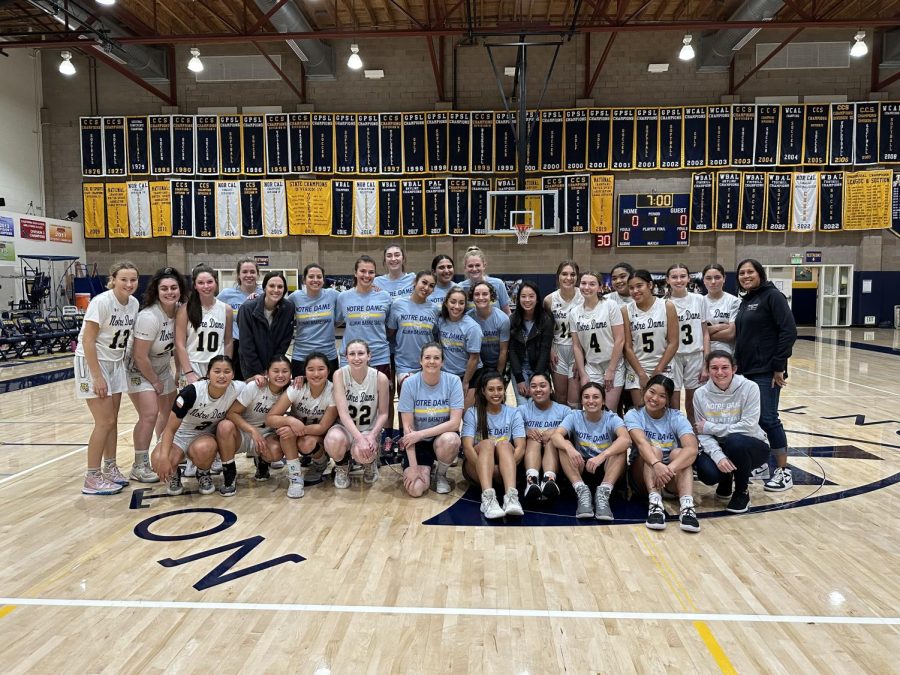 The current NDB Basketball team poses with the NDB Basketball alumni after winning the annual game.