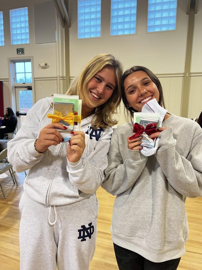 Juniors Annie Lester and Gianna Shaughnessy show off their care
packages that they made to be donated to homeless shelters.