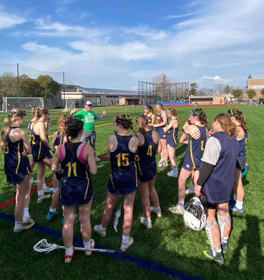 The Varsity Lacrosse team huddles around Varsity Head Coach Will Evans
to discuss plays at their recent game against Presentation HS.