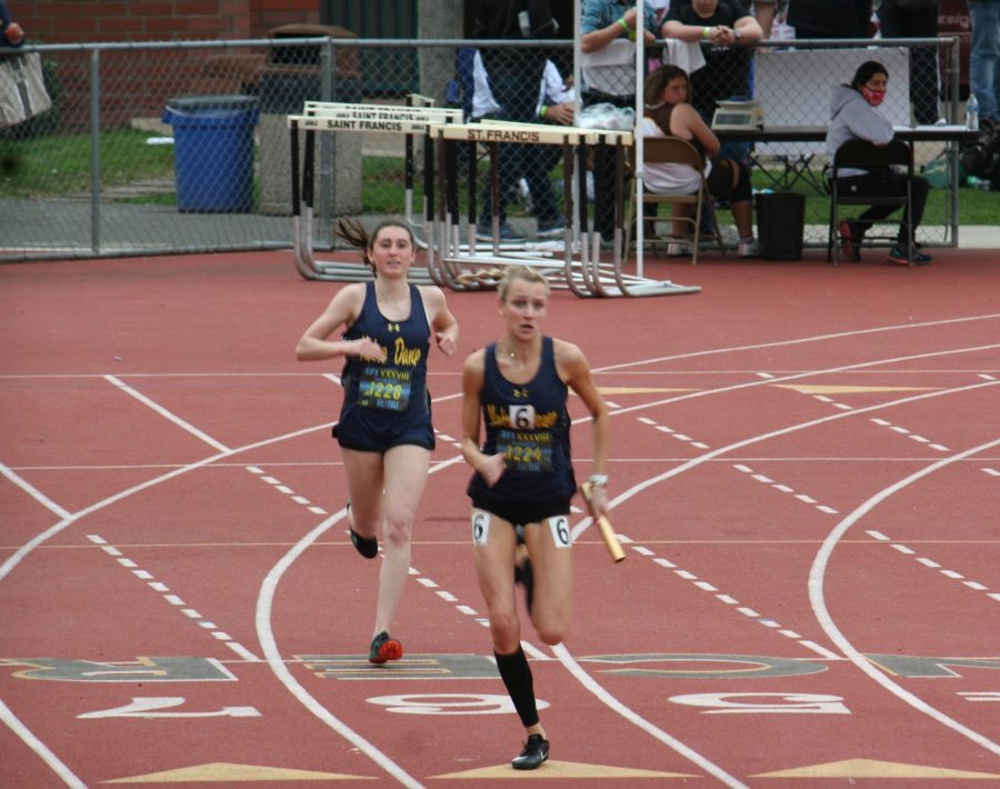 Junior Amber Holloway hands off the baton to senior Melanie Castelli to finish out their relay race.