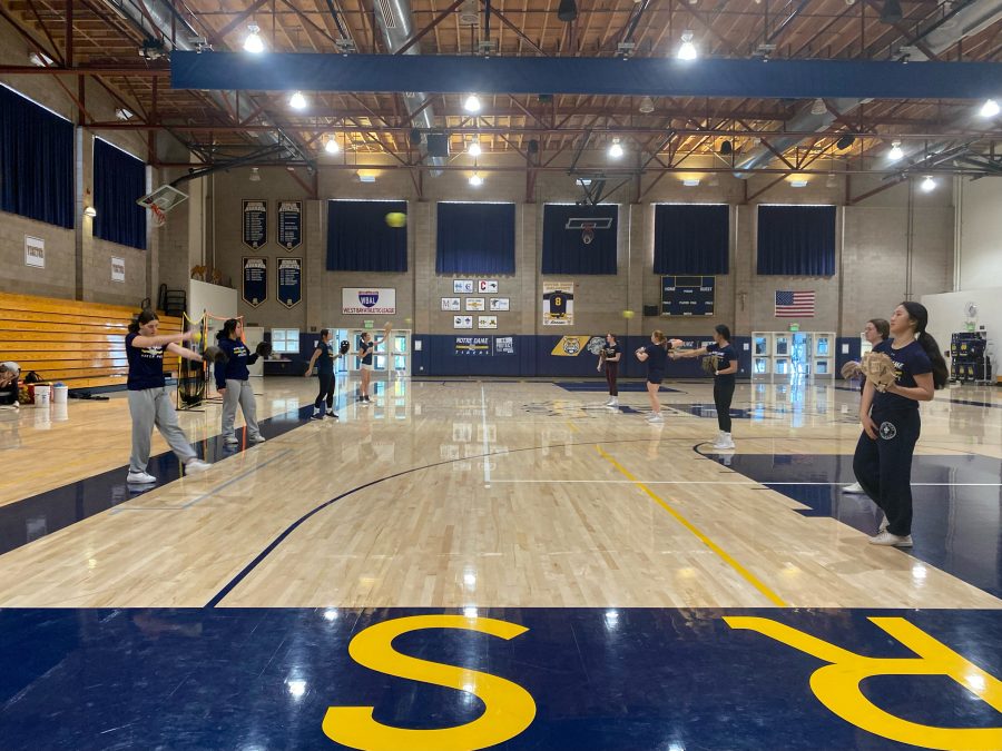 The softball team practices passing and catching indoors in NDB’s Moore Pavilion due to extreme weather and field conditions.
