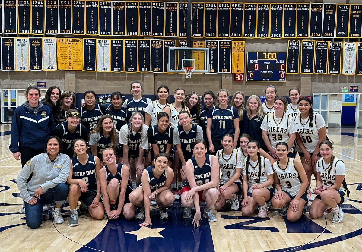 Current+and+alumnae+basketball+players+pose+before+the+start+of+the+match.