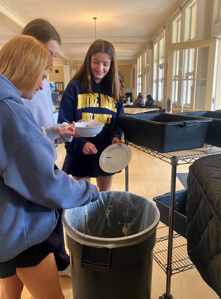 After lunch, students sort their food waste into the designated bins.