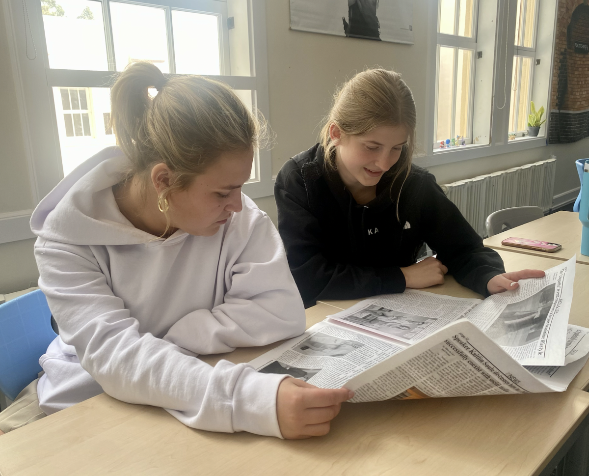 Seniors Annie Lester and Lauren Pope read the newspaper to build literacy skills.