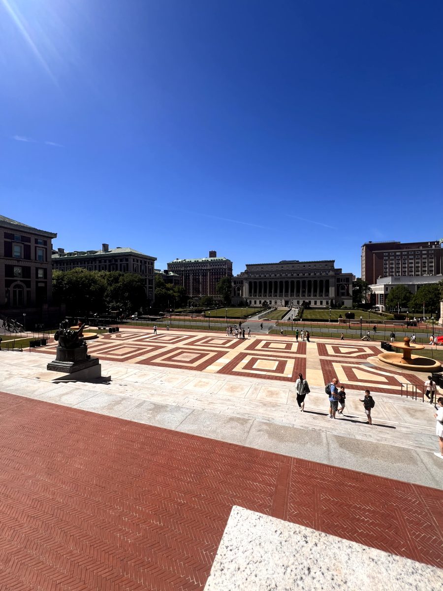 Students overlooking Columbia University's campus. Butler Library rests at end of the field.