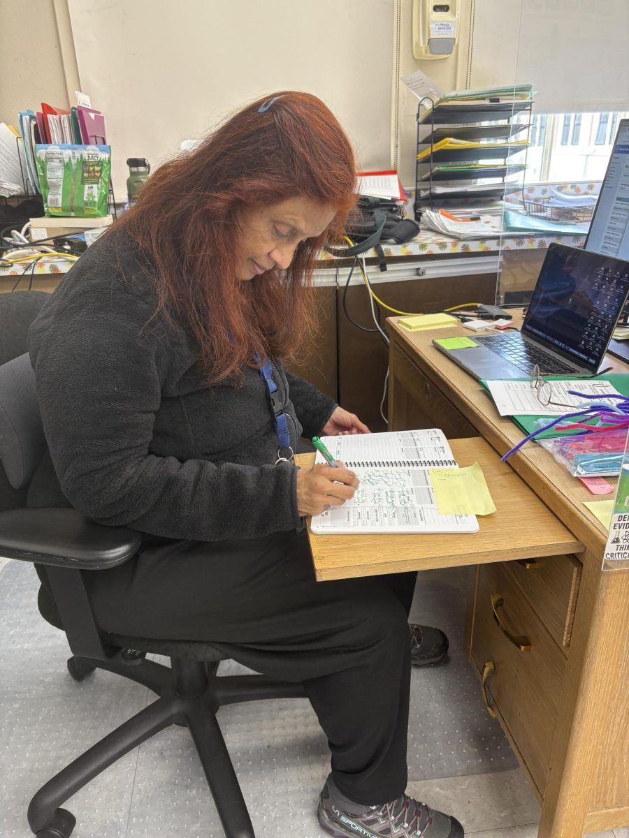 Dr. Srinivasan writing in her planner planning for final exams.