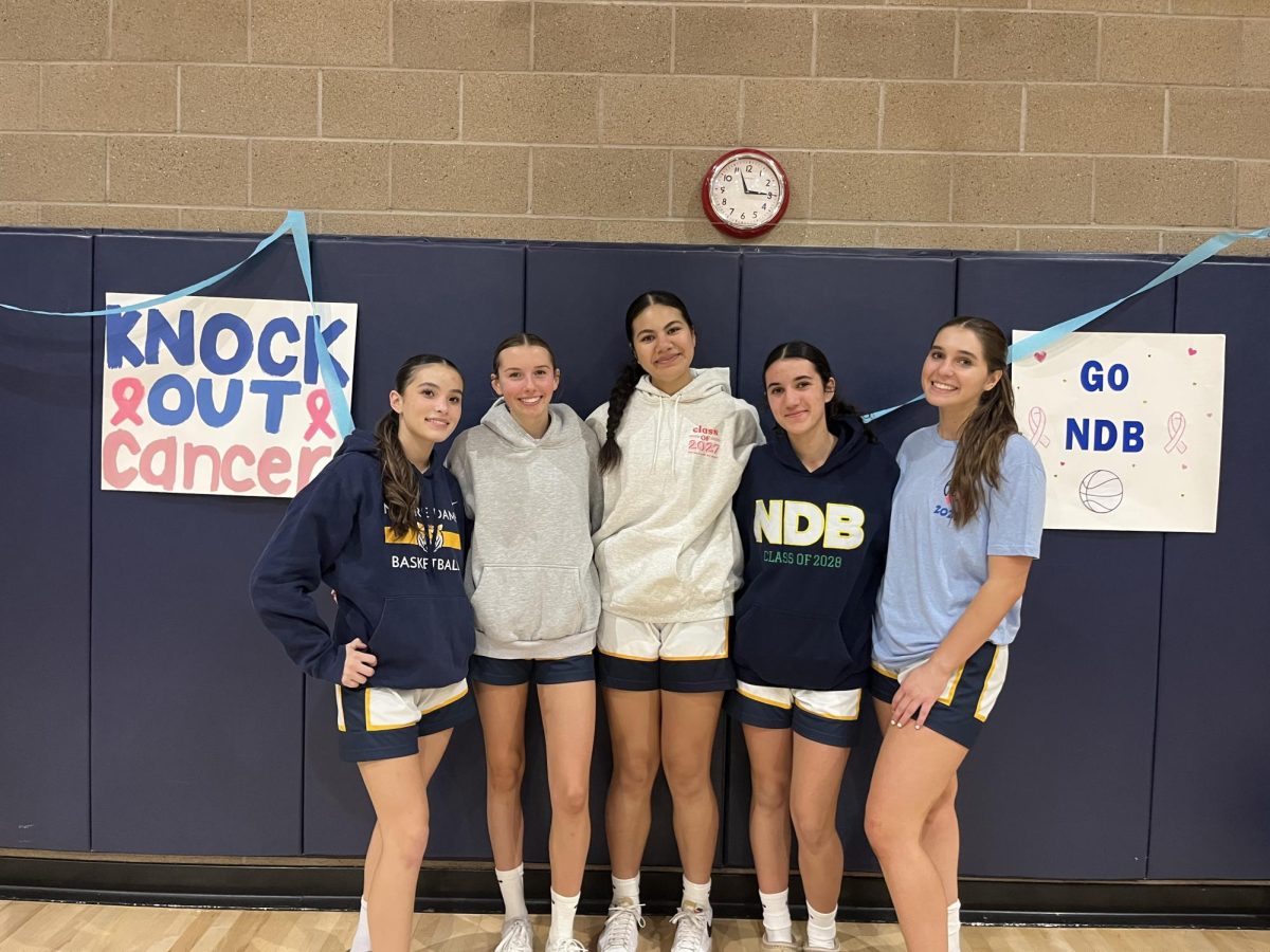 Varsity basketball team members Mika Cary, Julianna Loar, Sammy Kakala, Lorea Melander, and Lizzie Johnson pose after the game