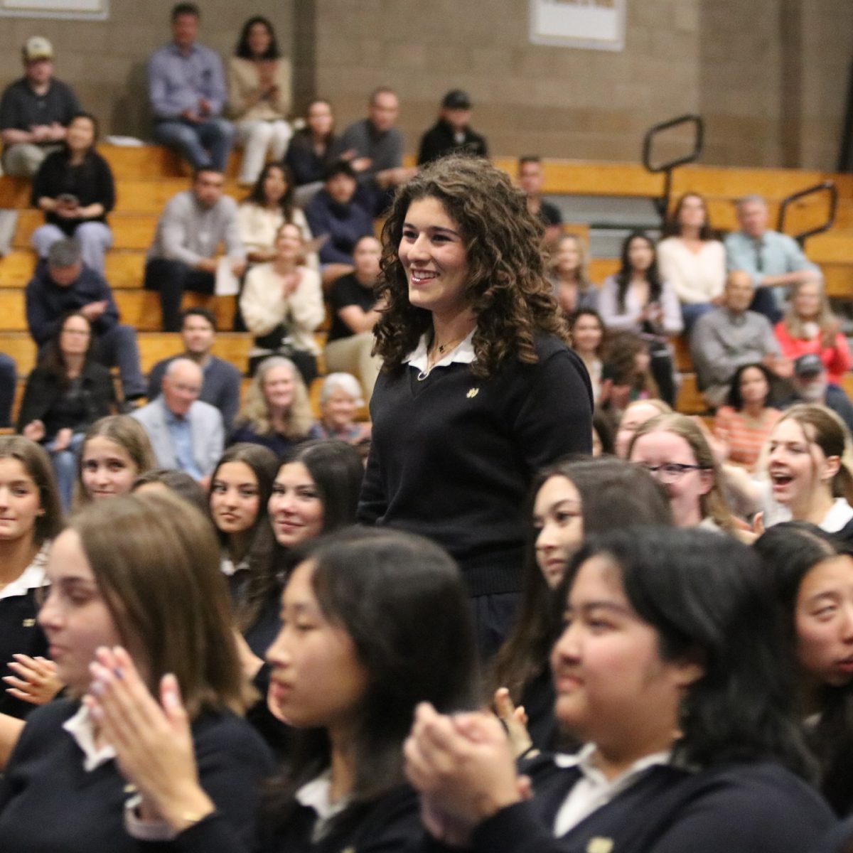 One of several students in attendance, junior Cecily Rambod approaches the podium to receive an award from a department chair.