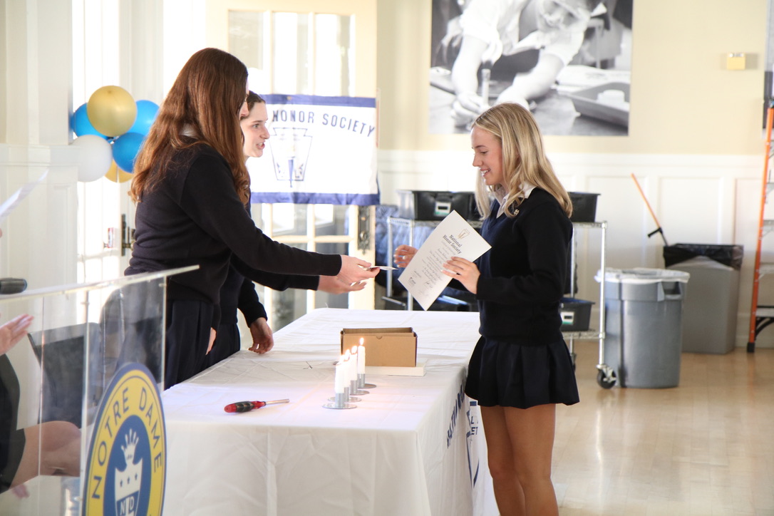 Junior Gianna Beltramo receives a certificate and pin to commemorate her induction.