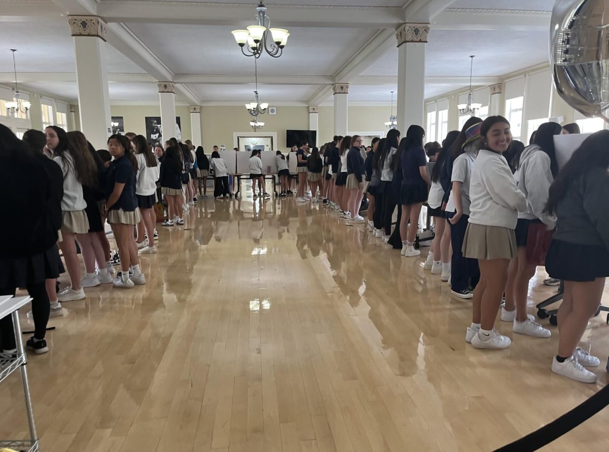 Club leaders standing behind their stations while students check out different booths.