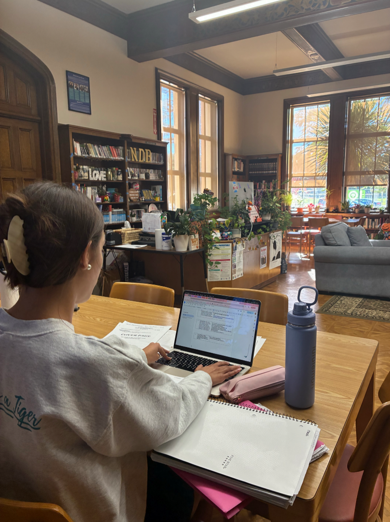 NDB student completing her homework in the library instead of catching up with friends after school.