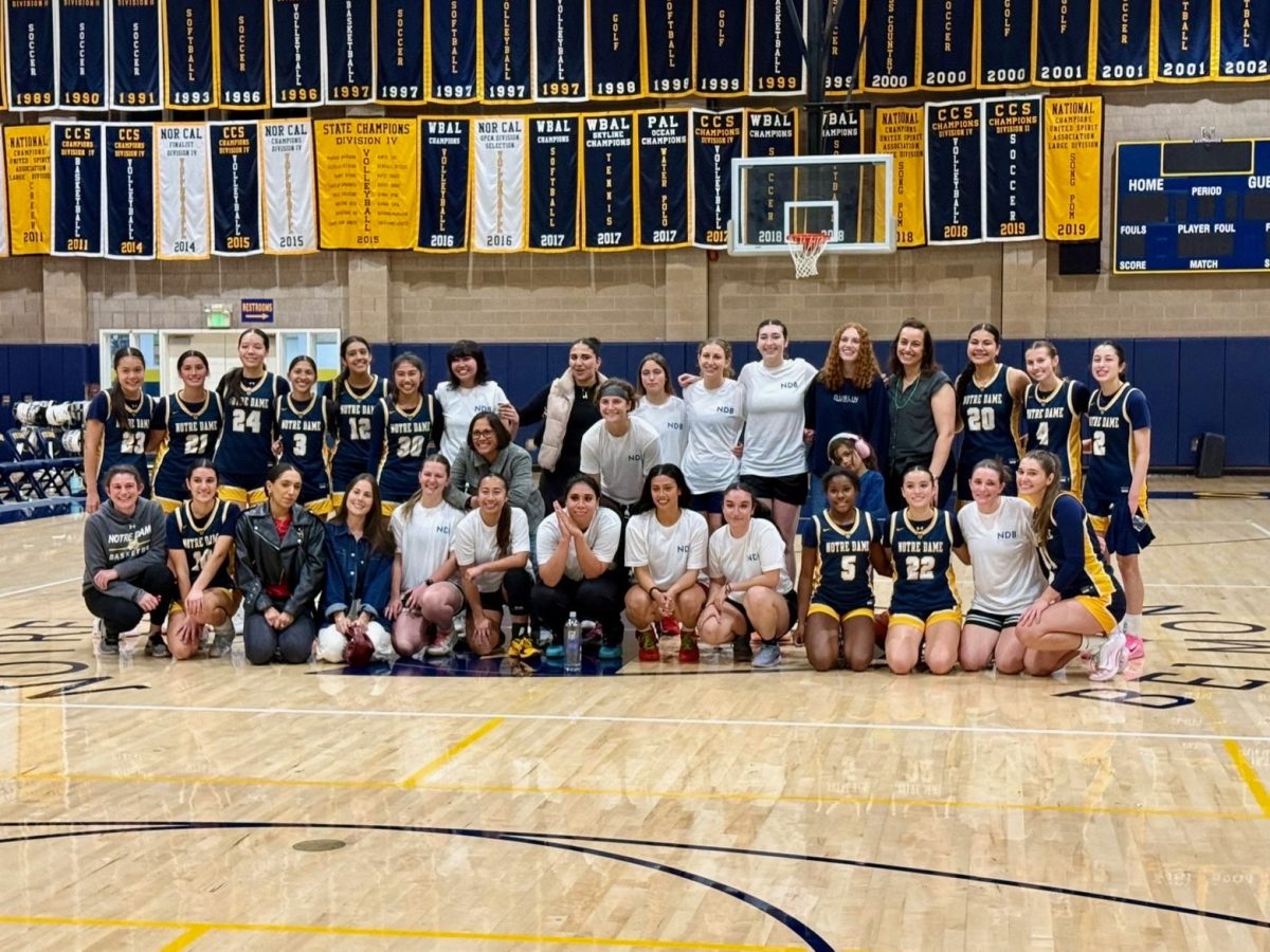 NDB's Varsity Basketball team poses with alumni after their alumni game.
