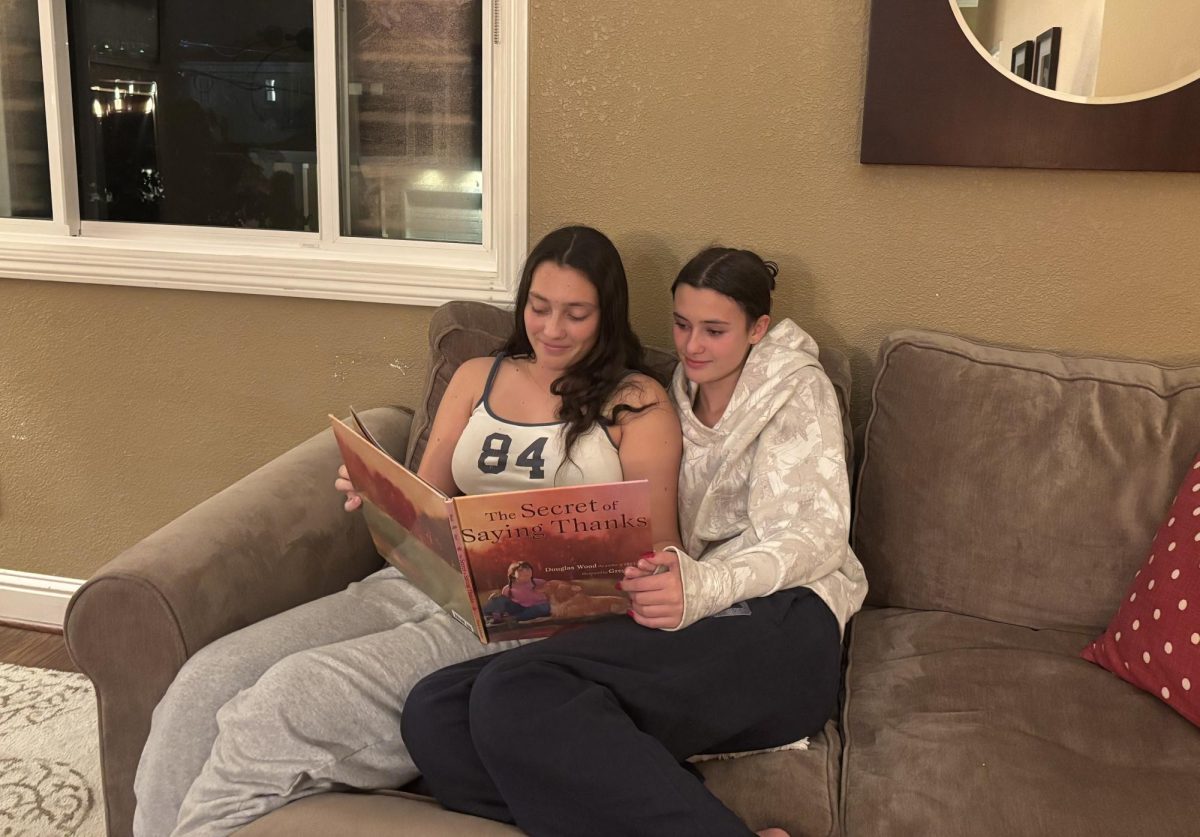 Maddie and Ashley Mitchell read a childhood holiday book together.