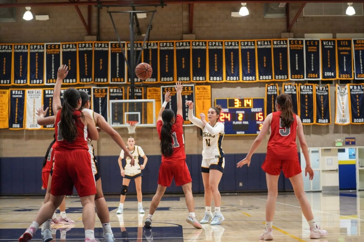 Senior Lizzie Johnson (#11) makes a pass during a recent basketball game.