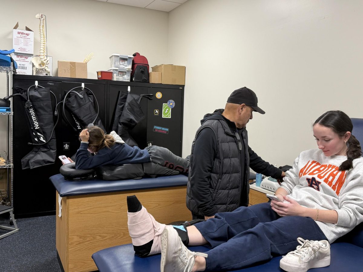 NDB Athletic Trainer Lazaro Cardenas (center) treats student athletes.