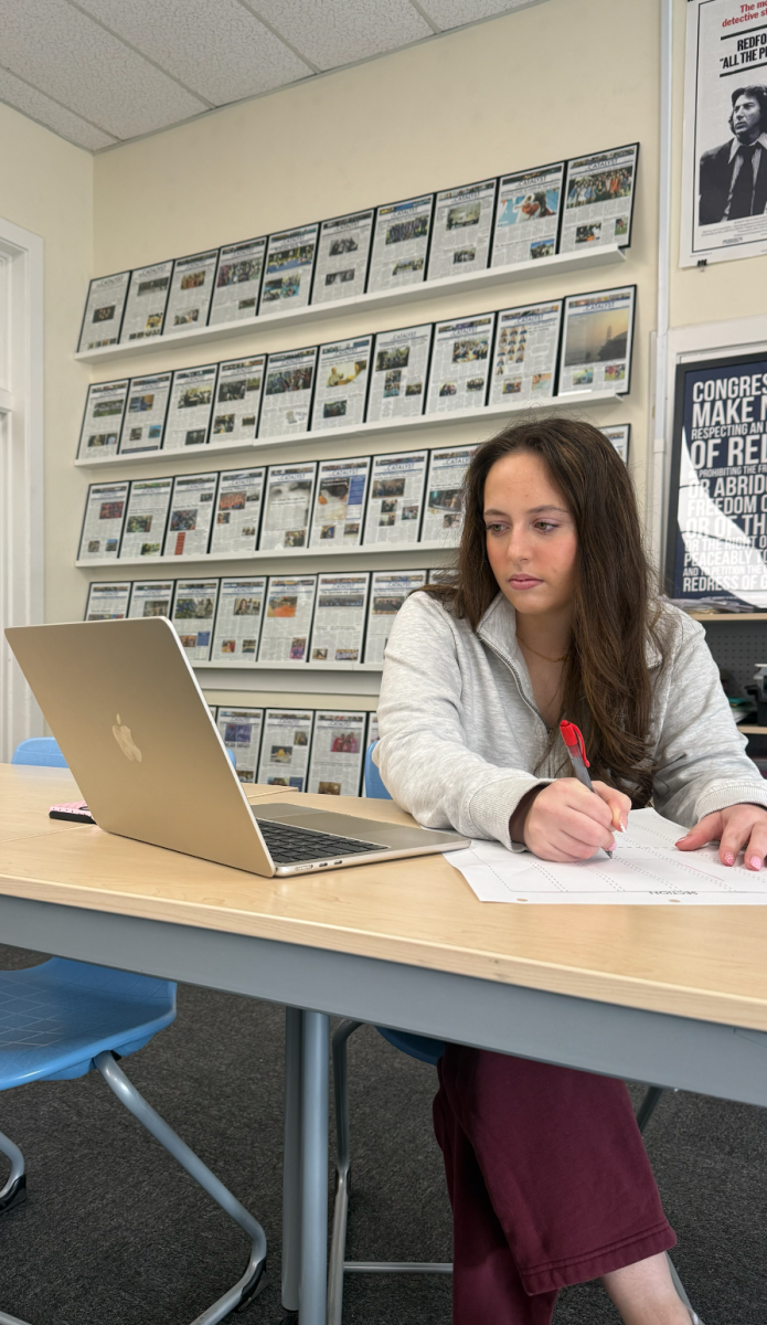 Page Krensavage sketches the front page design of The Catalyst’s last issue of the school year.
