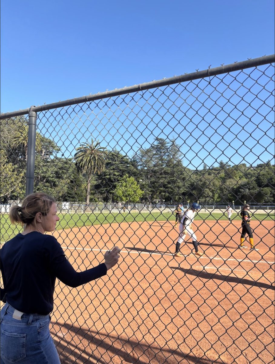 Athletic Director Laura Gill looking at a softball game being played. 